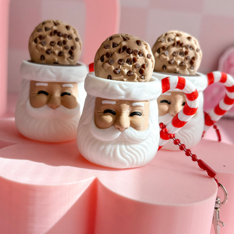 Santa Claus cookie jar fidget clicker with a cookie on top against a pink background