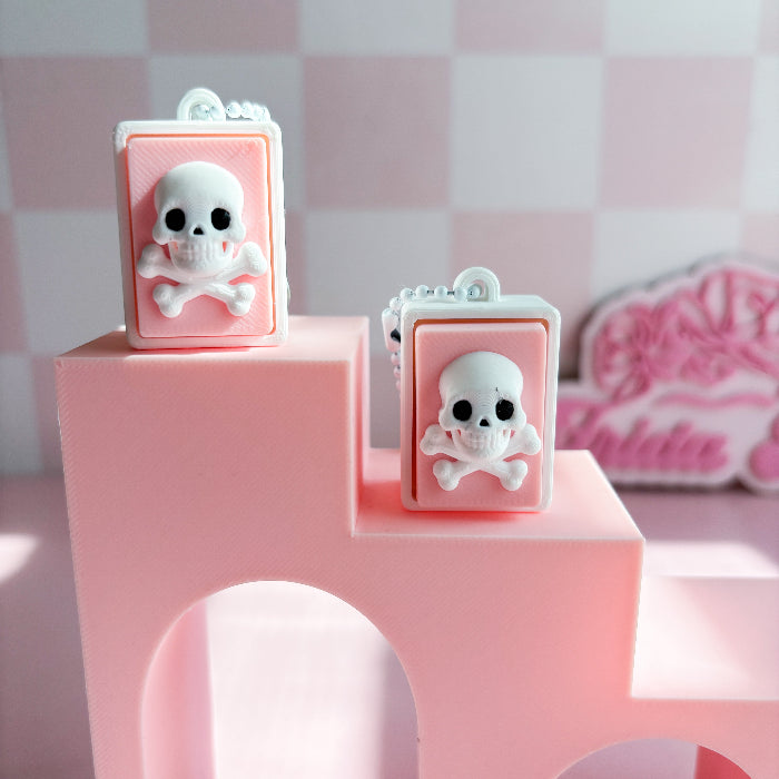 Mexican loteria fidget clicker  skull-shaped objects on a pink stand with a checkered background