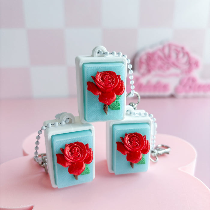 Merxican loteria fidget clickerwith red roses on a pink surface