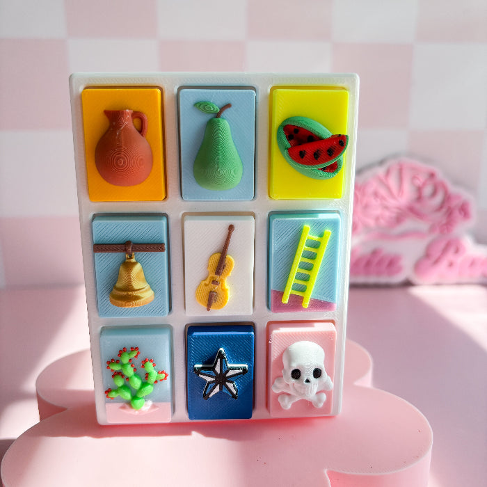 Set of colorful mexican loteria card fidget clicker on a pink stand with a checkered background