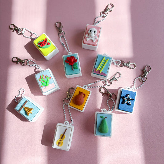 Collection of colorful keychains on a pink background