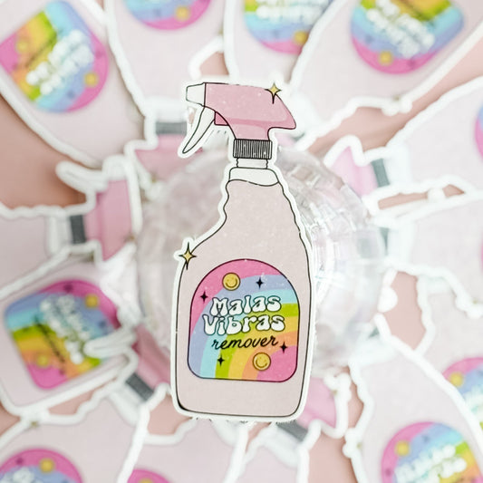 Sticker of a spray bottle labeled 'Malas Vibras remover' on a colorful background