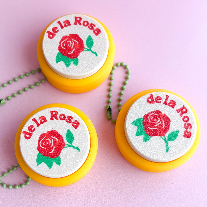 Three 'de la Rosa' branded items with red roses on a pink background