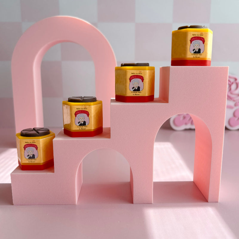 Pink arch-shaped display with yellow and red containers on a checkered background
