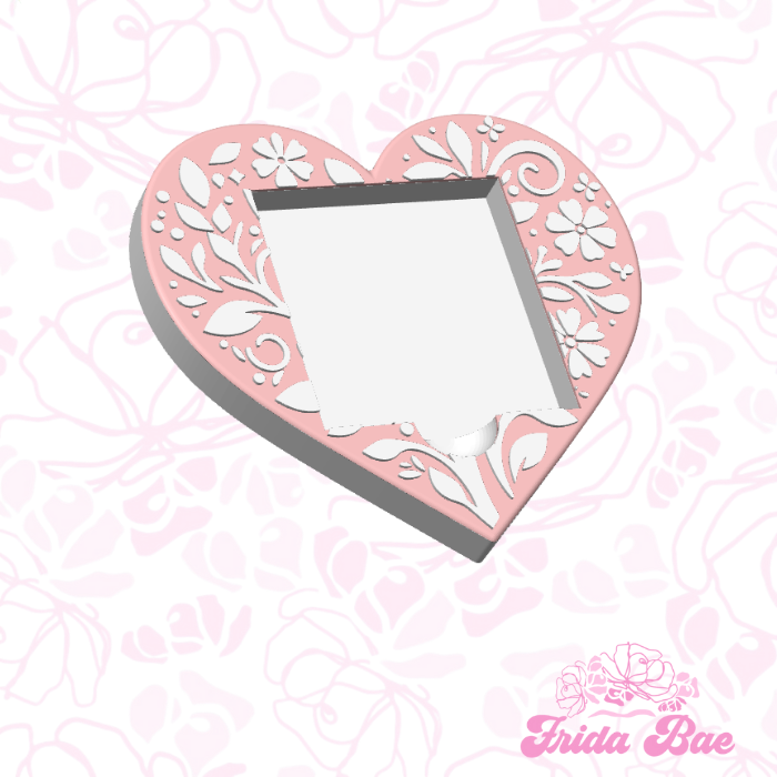 Heart-shaped stencil with floral design on a pink patterned background, featuring the brand 'frida Bae'.