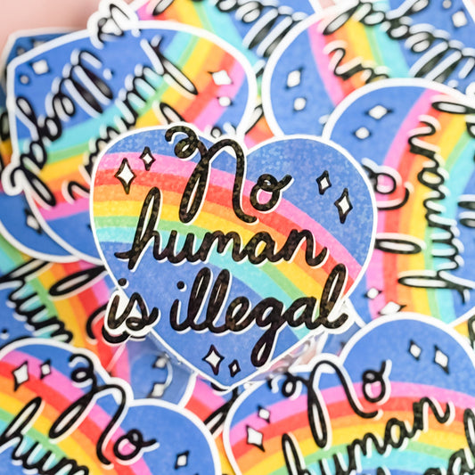 Stickers with 'No human is illegal' text on a rainbow heart design.