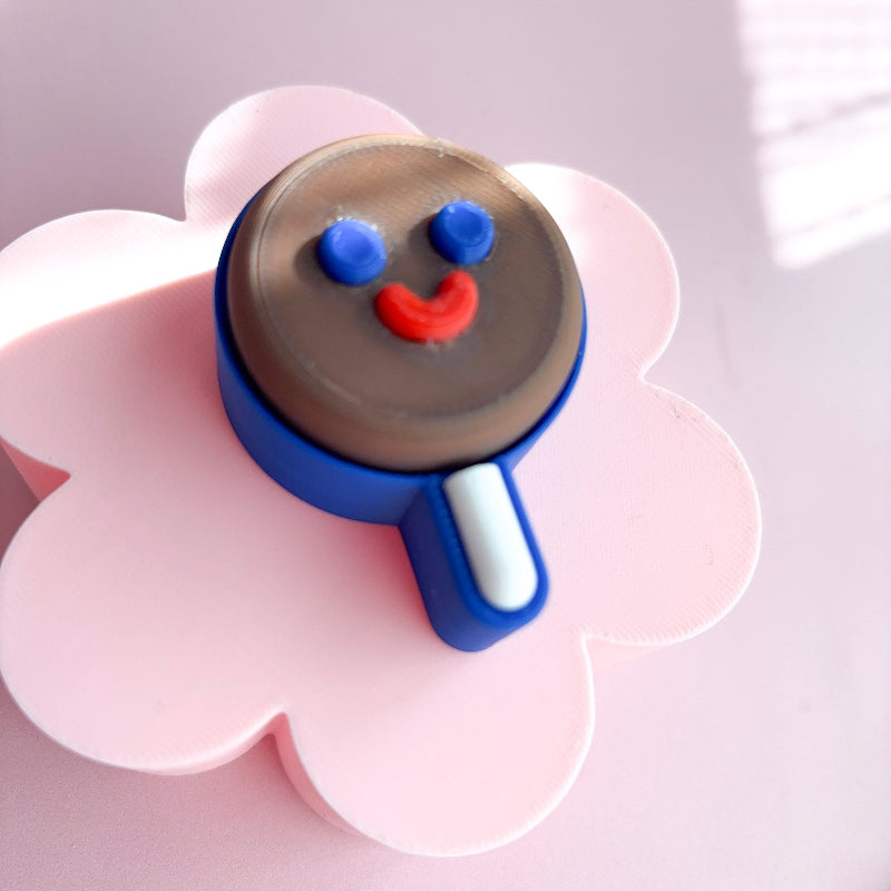 Five ice cream cone-shaped cookies with face designs on a pink background