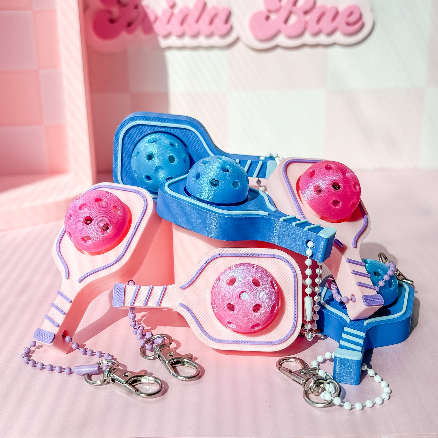 pink and blue pickleball shaped fidget clicker on a pink background