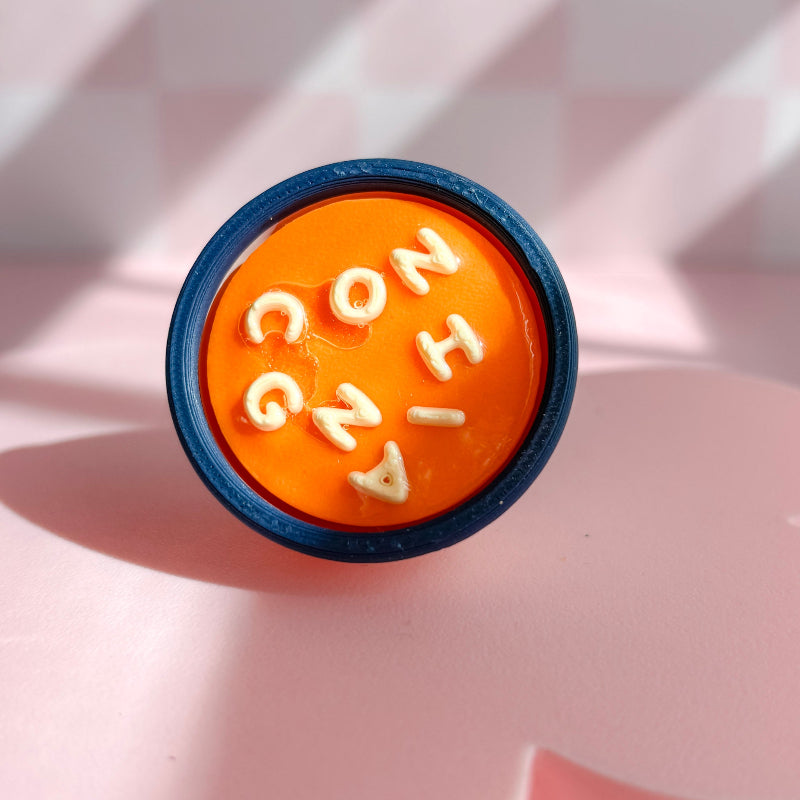 Orange soup clicker with lettering on a pink background