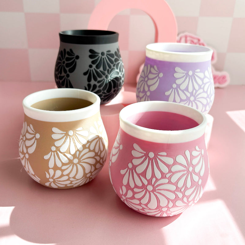 Four 3D Printed cups with floral patterns on a pink surface