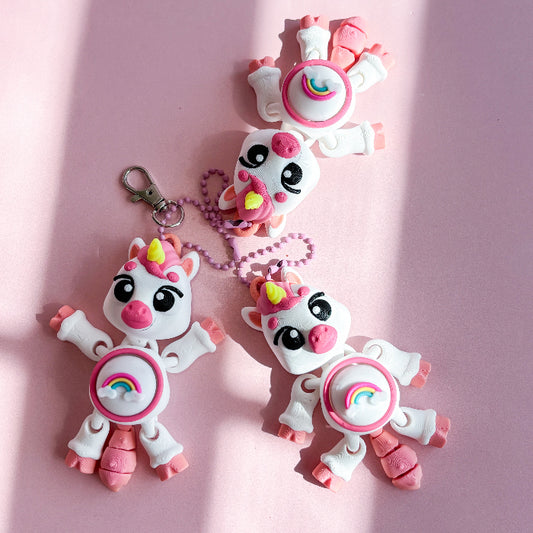 Two pink and white unicorn-shaped fidget toys on a pink background