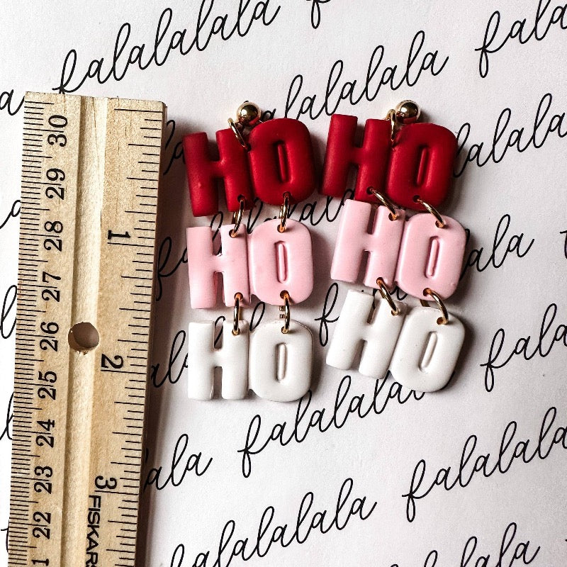 Light up the holiday season with these fun and festive "Ho Ho Ho" Dangle Earrings! Crafted from durable polymer clay, these earrings feature a bright and cheery palette of pink, red, and white to bring some festive flavor to your look. Get into the Christmas spirit with HO HO HO DANGLE EARRINGS!