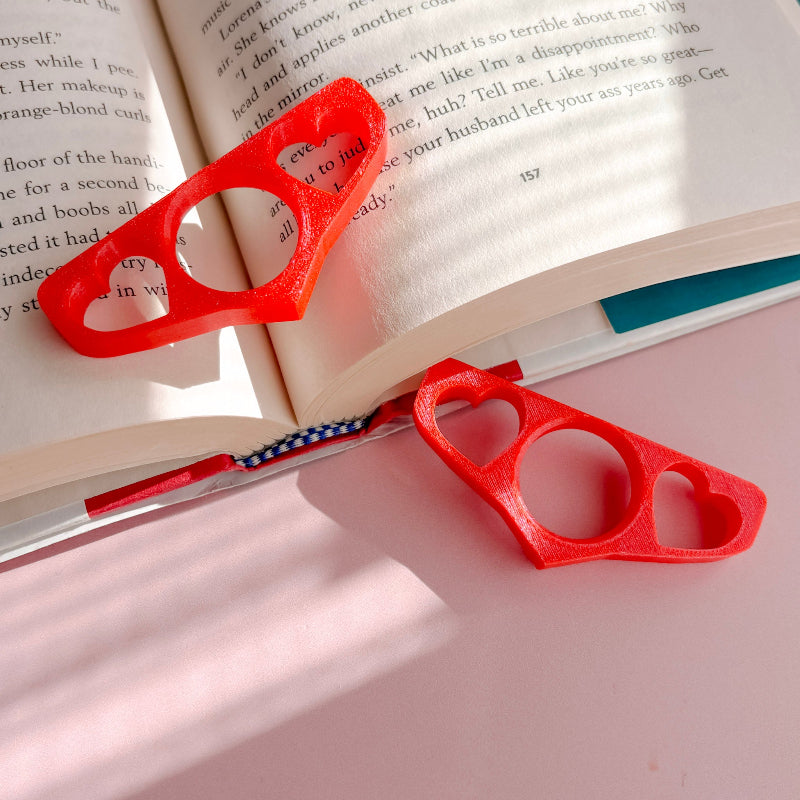 Book holder with hearts on an open book with a pink background