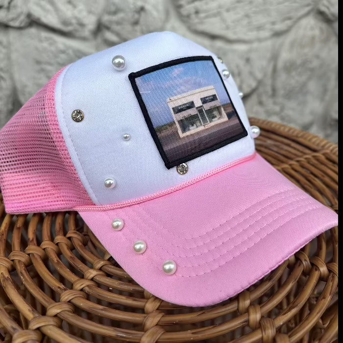 Pink and white foam trucker with prada marfa patch and pearls