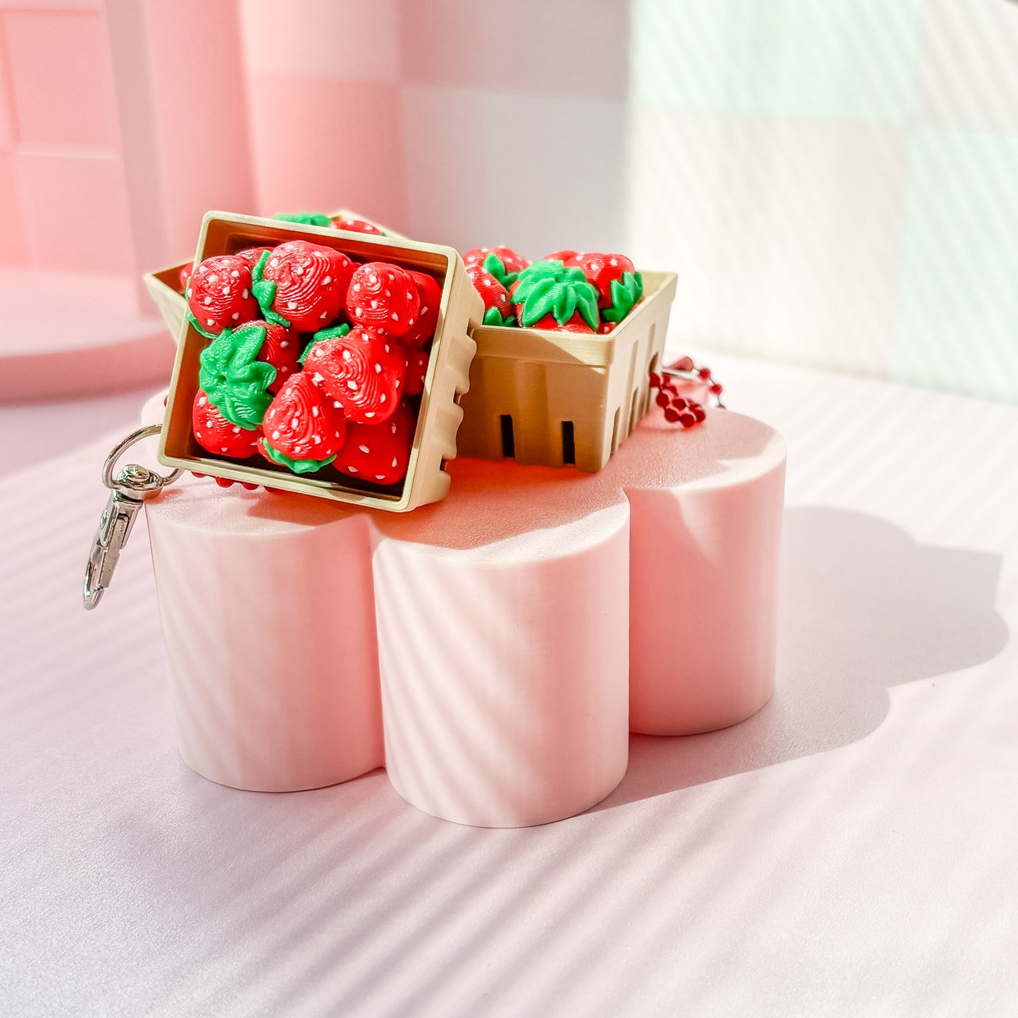 Strawberry-themed fidget clicker on pink stands with 'Frida Bae' branding in the background