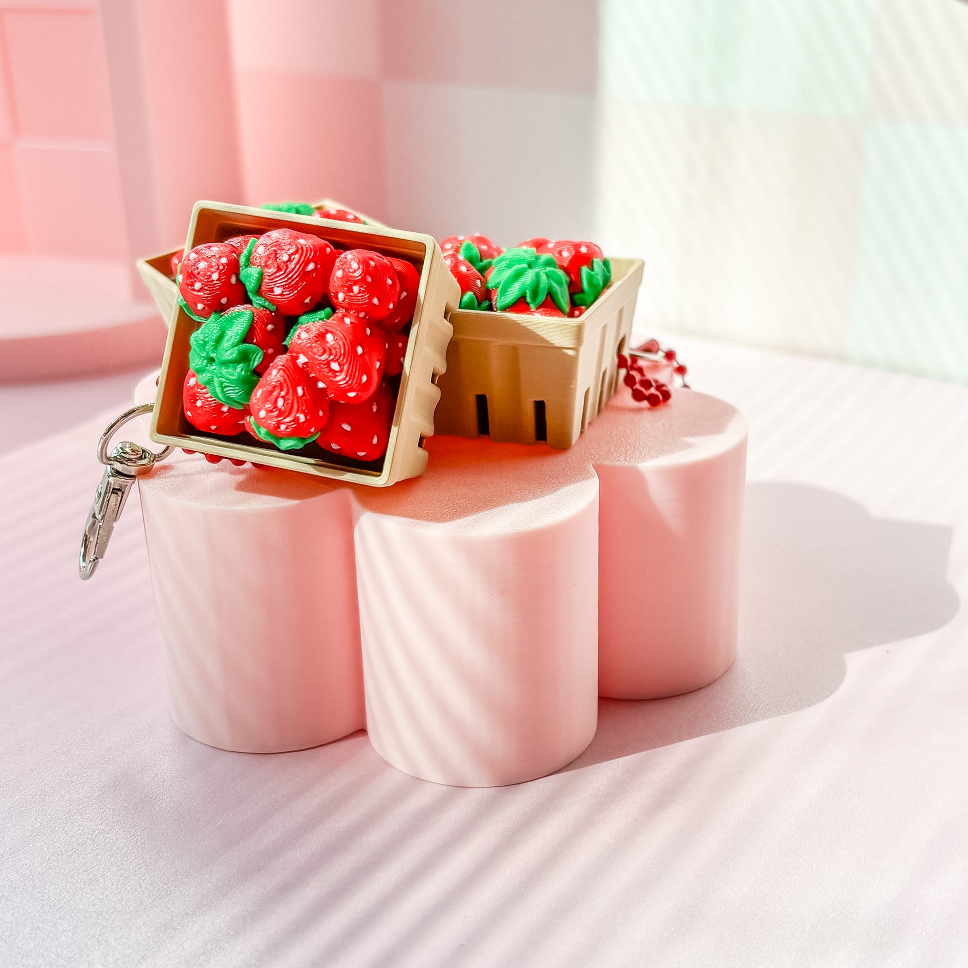 Strawberry-themed fidget clicker on pink stands with 'Frida Bae' branding in the background